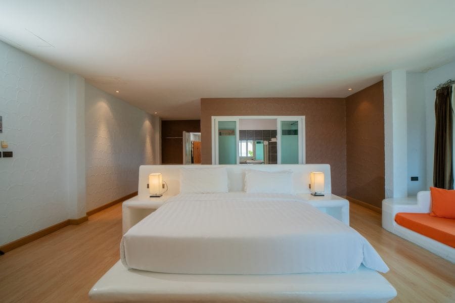 Brightly colored bedroom showcasing a white bed with striking orange pillows at Phuket Island Rehab the best rehab Thailand, ideal for rejuvenation and relaxation.