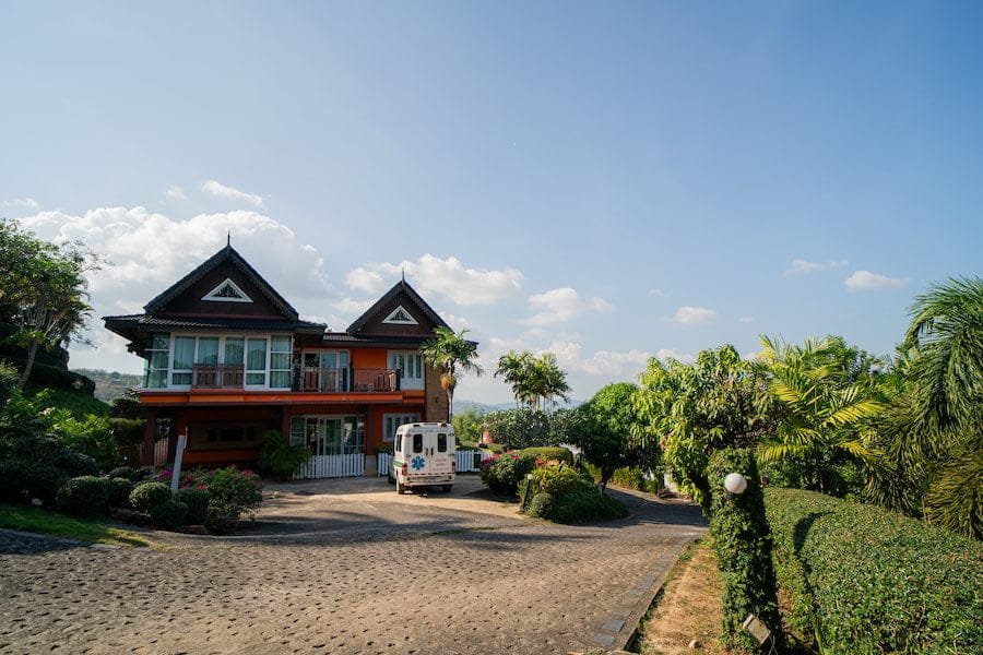 A house with a driveway and a parked vehicle, illustrating the serene atmosphere of rehab Thailand facilities.